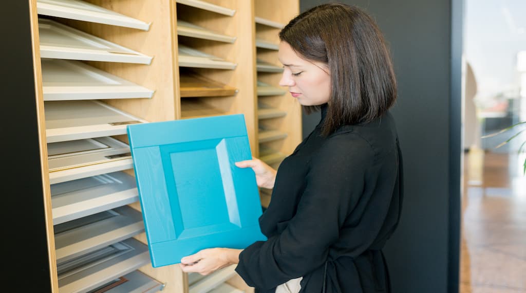 Designer Woman Choosing Kitchen Cabinet